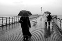 PHOTOGRAPHER WALES WOMAN ON PEIR WITH UMBRELLA